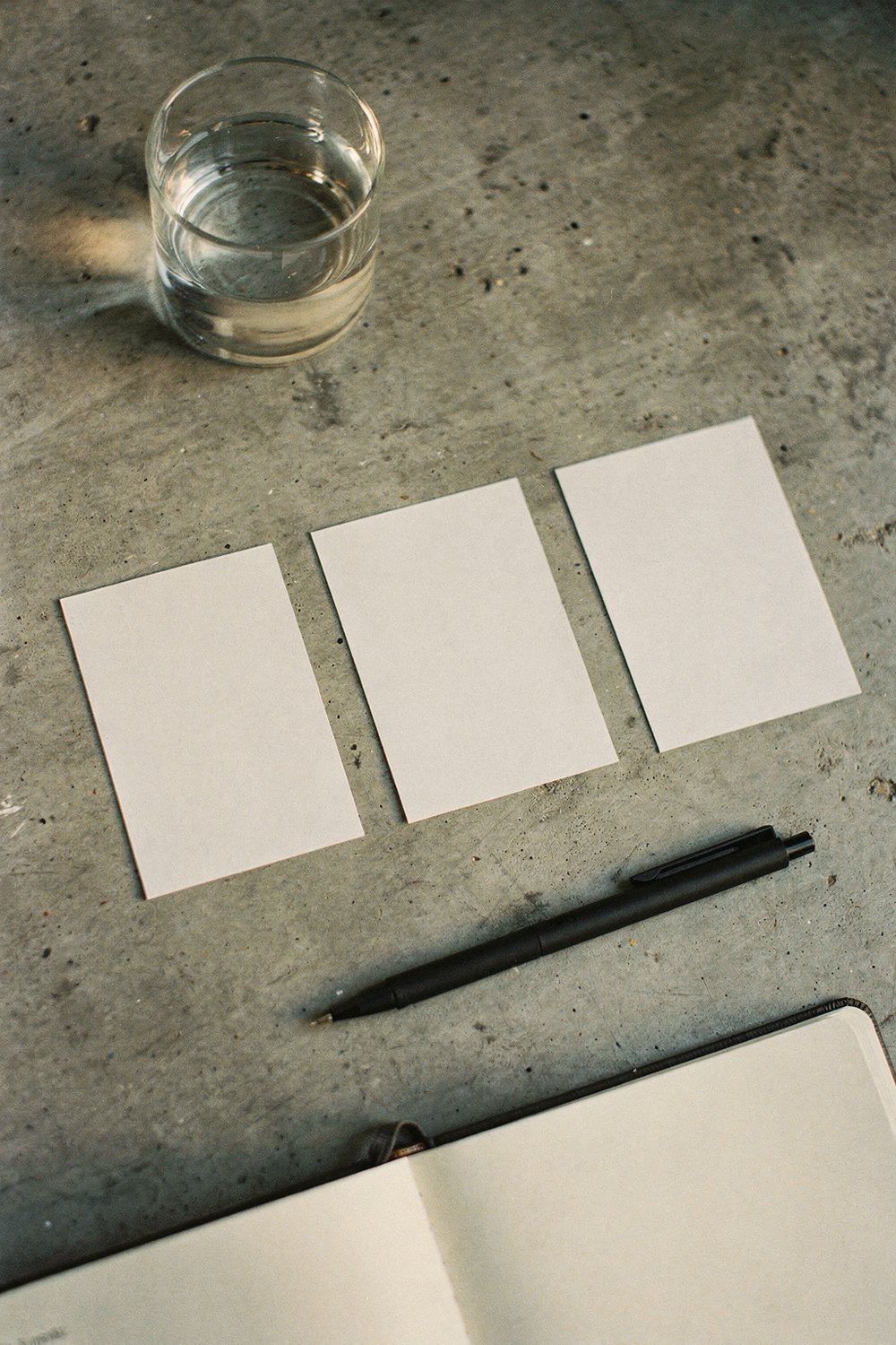 Four index cards numbered 1-4 in a row with a pen and water glass